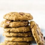 A stack of Chocolate Chip Coffee Cookies with one cookie leaning up against the stack.