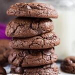 Stack of chocolate chip mocha cookies with a mason jar of milk in background.