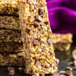 A stack of chocolate chip granola bars with one leaning up the side.