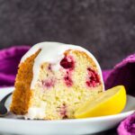 Slice of lemon raspberry bundt cake on a small white plate with a fork.