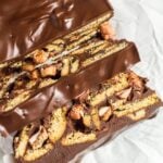 Overhead shot of chocolate fridge cake with two slices cut out on parchment paper.