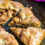 Homemade apple galette with two slices cut out on a baking tray.