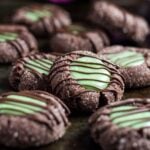 Chocolate thumbprint cookies with a mint filling on a baking tray.