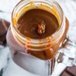 A mason jar filled with thick salted chocolate caramel sauce.