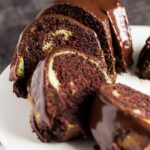 Slices of mint chocolate bundt cake served on a white cake stand.