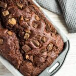 An overhead shot of Double Chocolate Banana Bread studded with chocolate chunks in a loaf pan.
