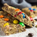 A close-up shot of No-Bake Peanut Butter M&M Granola Bars overlapping each other.