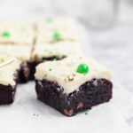 A Bailey’s Irish Cream brownie sitting on parchment paper, highlighting its thick frosting and decorative sprinkles.